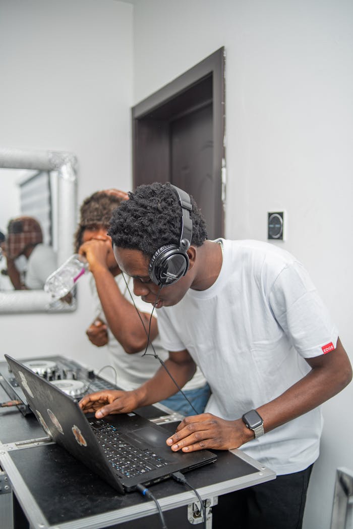 Two young DJs engaged in a live music mixing session indoors.