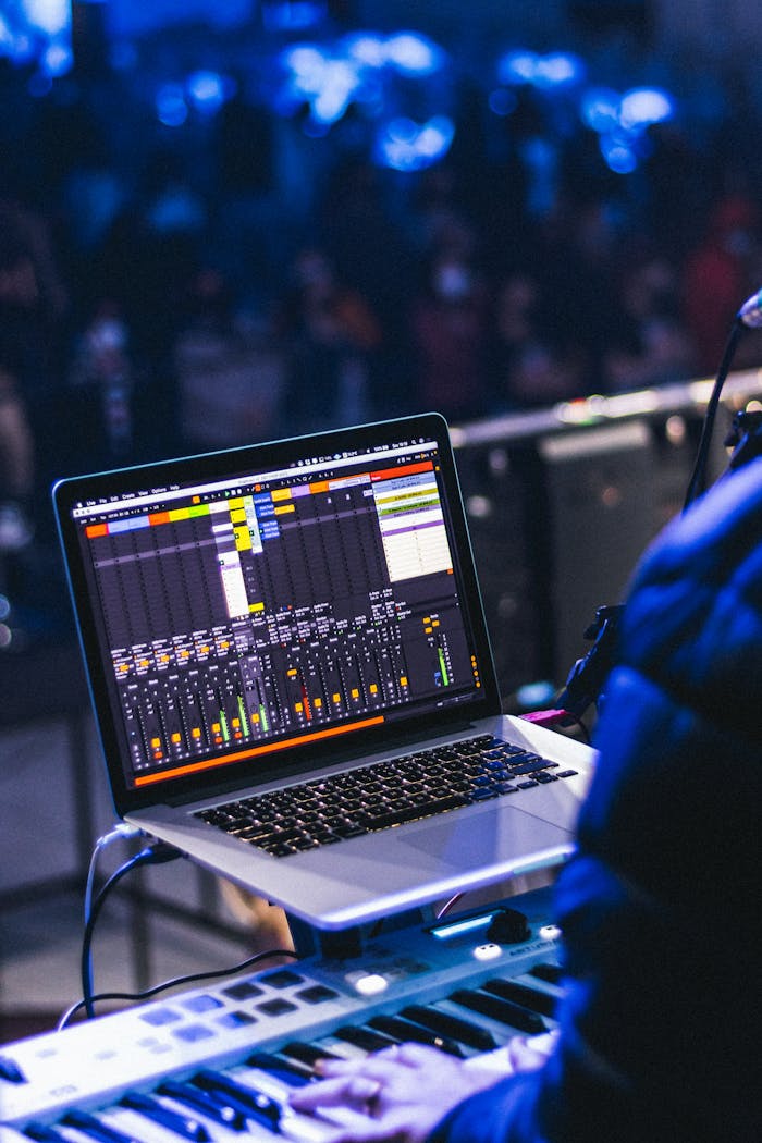Musician using laptop for mixing during live performance in concert setting