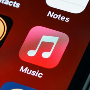 Detailed close-up of an iPhone home screen featuring the music app icon.